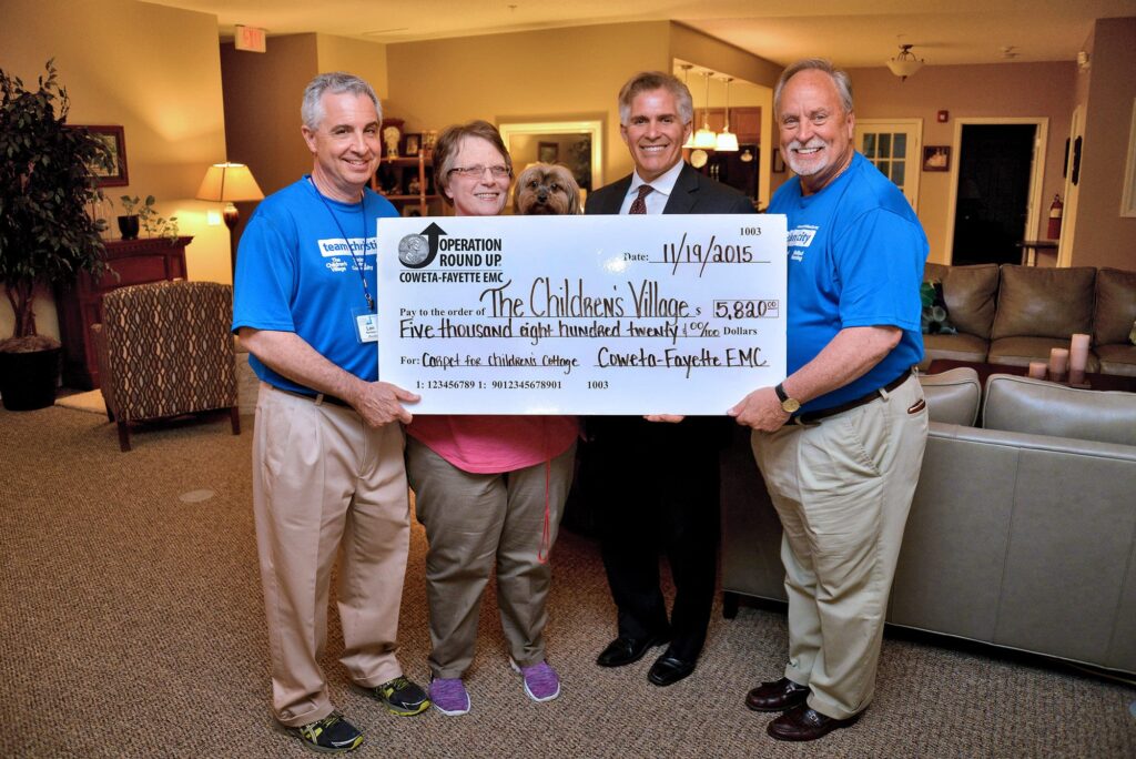A grant from Coweta Fayette EMC Operation Round Up paid for the replacement of carpeting at The Children’s Village at Christian City. From left, Len Romano, Christian City CEO; Kay Harkness, Lead House Parent at The Children’s Village; Coweta-Fayette EMC Trust Board Vice Chair, Glenn Valencia; and Philip Kouns, The Children’s Village COO. Pictured in the center is Kay’s precious and faithful pet dog, Jake. 